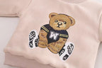 Pink kids sweatshirt with embroidered teddy bear in sports jersey and sneakers, soft fabric, cozy design