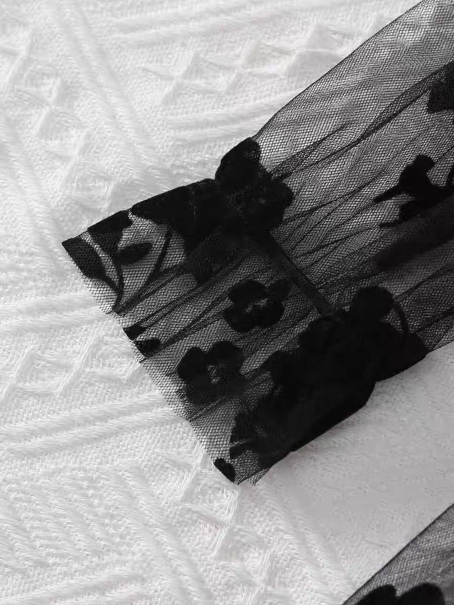 Vestido negro real acompañado de zapatos a juego y bolso