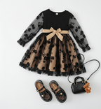 Vestido negro real acompañado de zapatos a juego y bolso