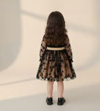 Vestido negro real acompañado de zapatos a juego y bolso