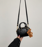 Vestido negro real acompañado de zapatos a juego y bolso