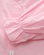 Pink children's blouse with ruffled sleeve detail and button closure, soft fabric for comfort